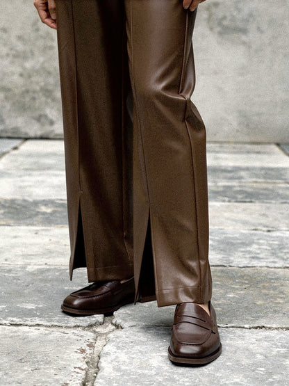 Split hem detail of the floor length faux leather trousers