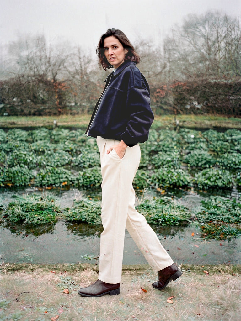 Slate navy faux suede bomber jacket worn walking beside English watercress beds