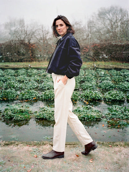 Slate navy faux suede bomber jacket worn walking beside English watercress beds