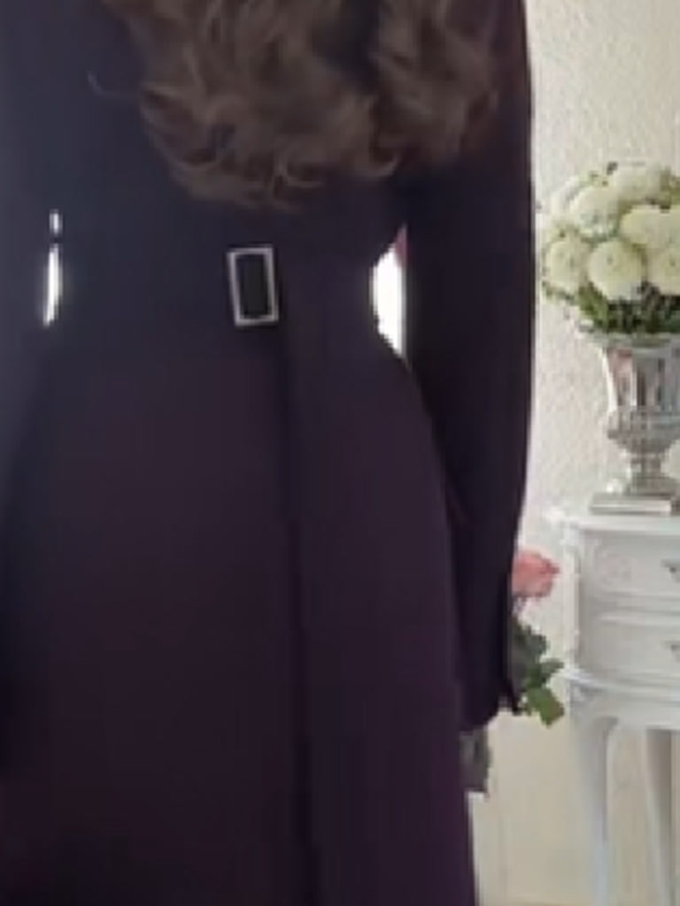 Back of the fitted longline coat showing the narrow self fabric belt and its rectangular metal buckle