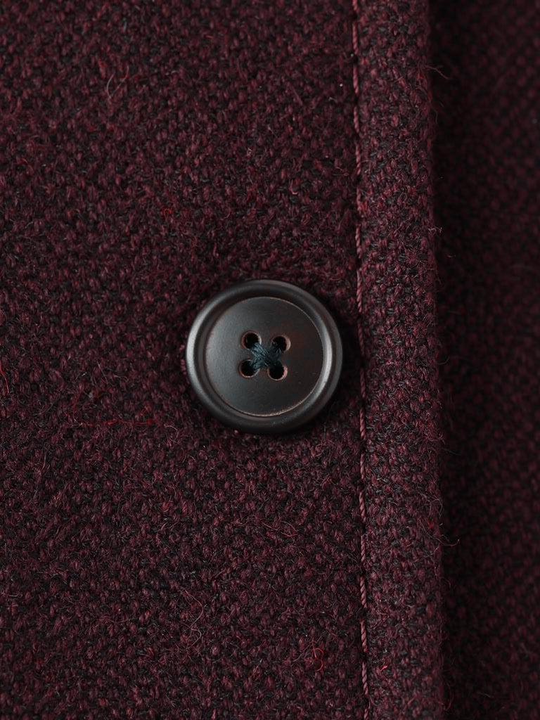 Close up of the matte horn button and the dense brushed cloth of the Cabernet burgundy longline coat