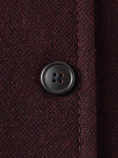 Close up of the matte horn button and the dense brushed cloth of the Cabernet burgundy longline coat