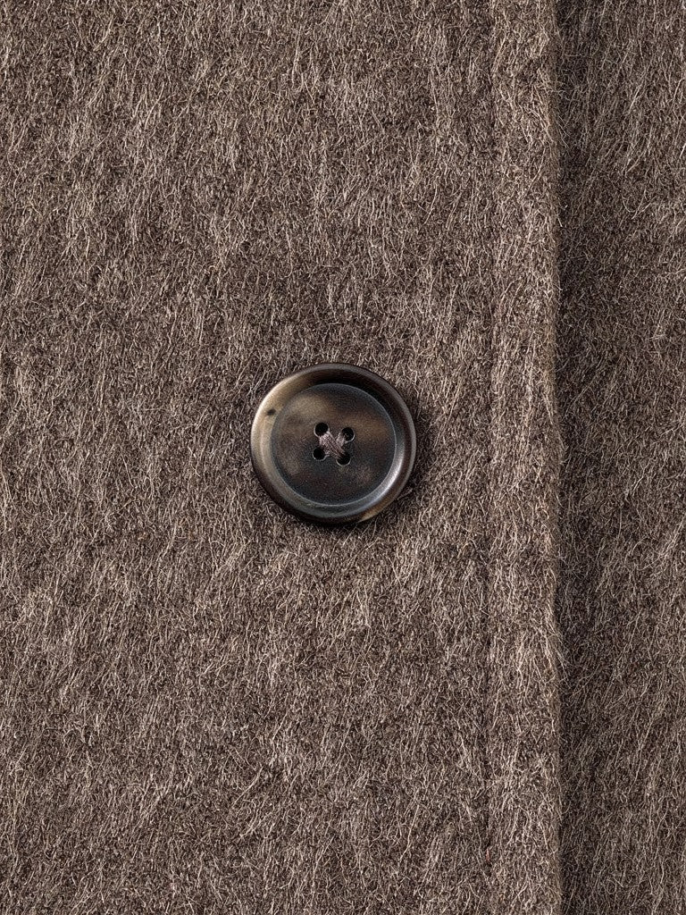 Close-up of the brushed wool blend and a matte horn button on the funnel neck coat