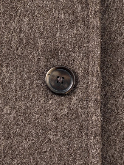 Close-up of the brushed wool blend and a matte horn button on the funnel neck coat