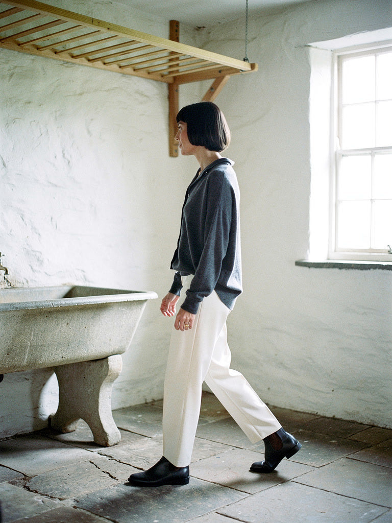 Grey cashmere cardigan worn open over cream trousers in Basalt