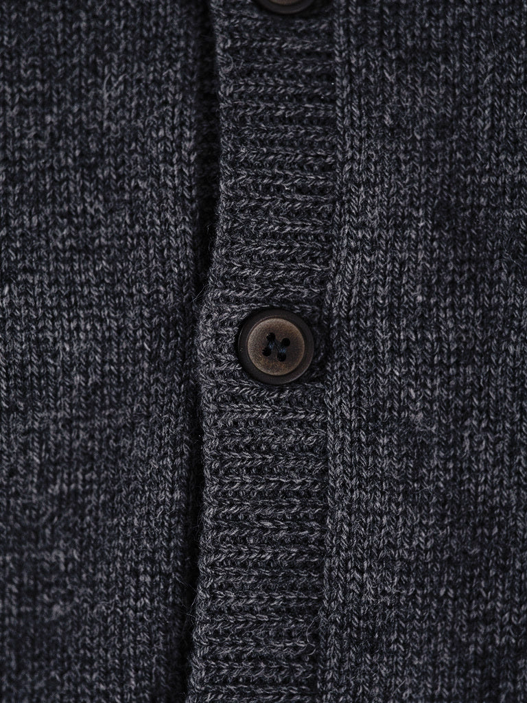 Close-up of the smooth cashmere knit and matte buttons of the grey cardigan