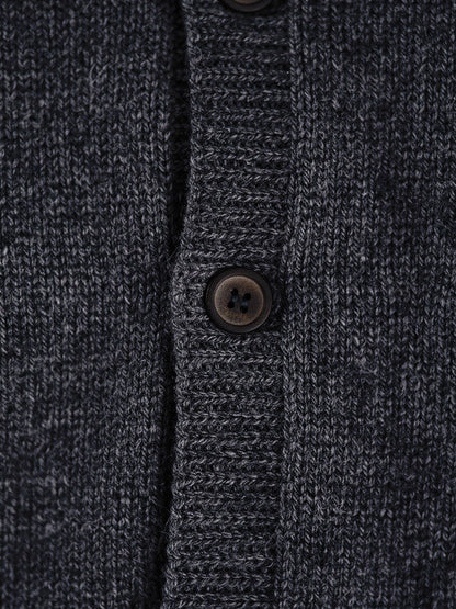 Close-up of the smooth cashmere knit and matte buttons of the grey cardigan