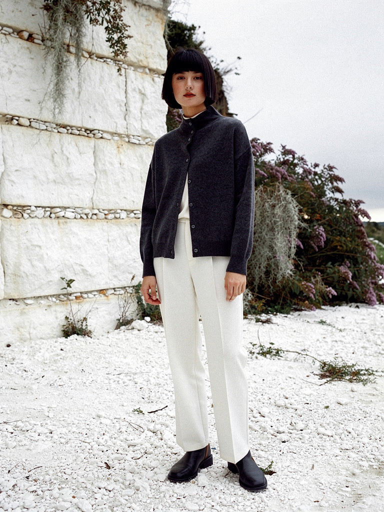 Woman wearing a grey cashmere cardigan with a buttoned stand collar in Basalt