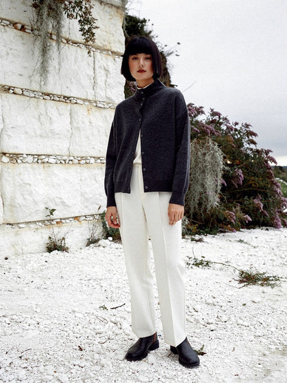 Woman wearing a grey cashmere cardigan with a buttoned stand collar in Basalt