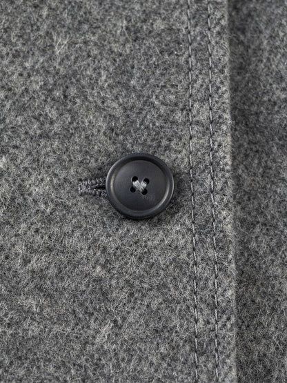 Close up of the brushed double faced wool and the flat four hole button of the grey wool coat