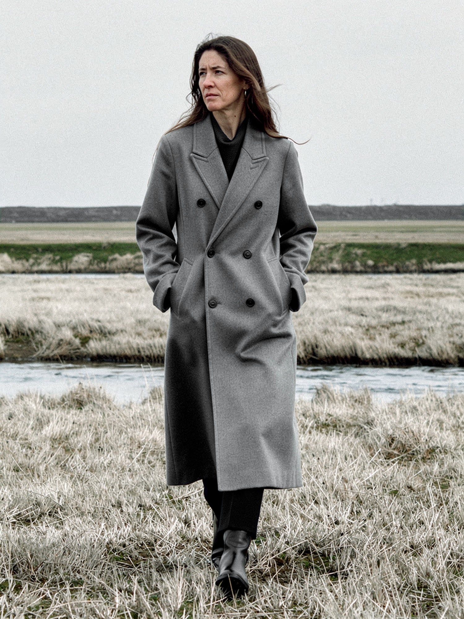 Grey wool coat worn open on a salt marsh, double breasted and oversized, falling to mid calf