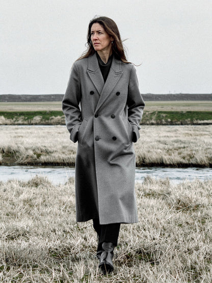 Grey wool coat worn open on a salt marsh, double breasted and oversized, falling to mid calf