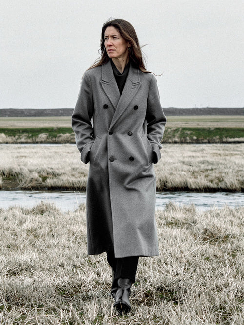 Grey wool coat worn open on a salt marsh, double breasted and oversized, falling to mid calf