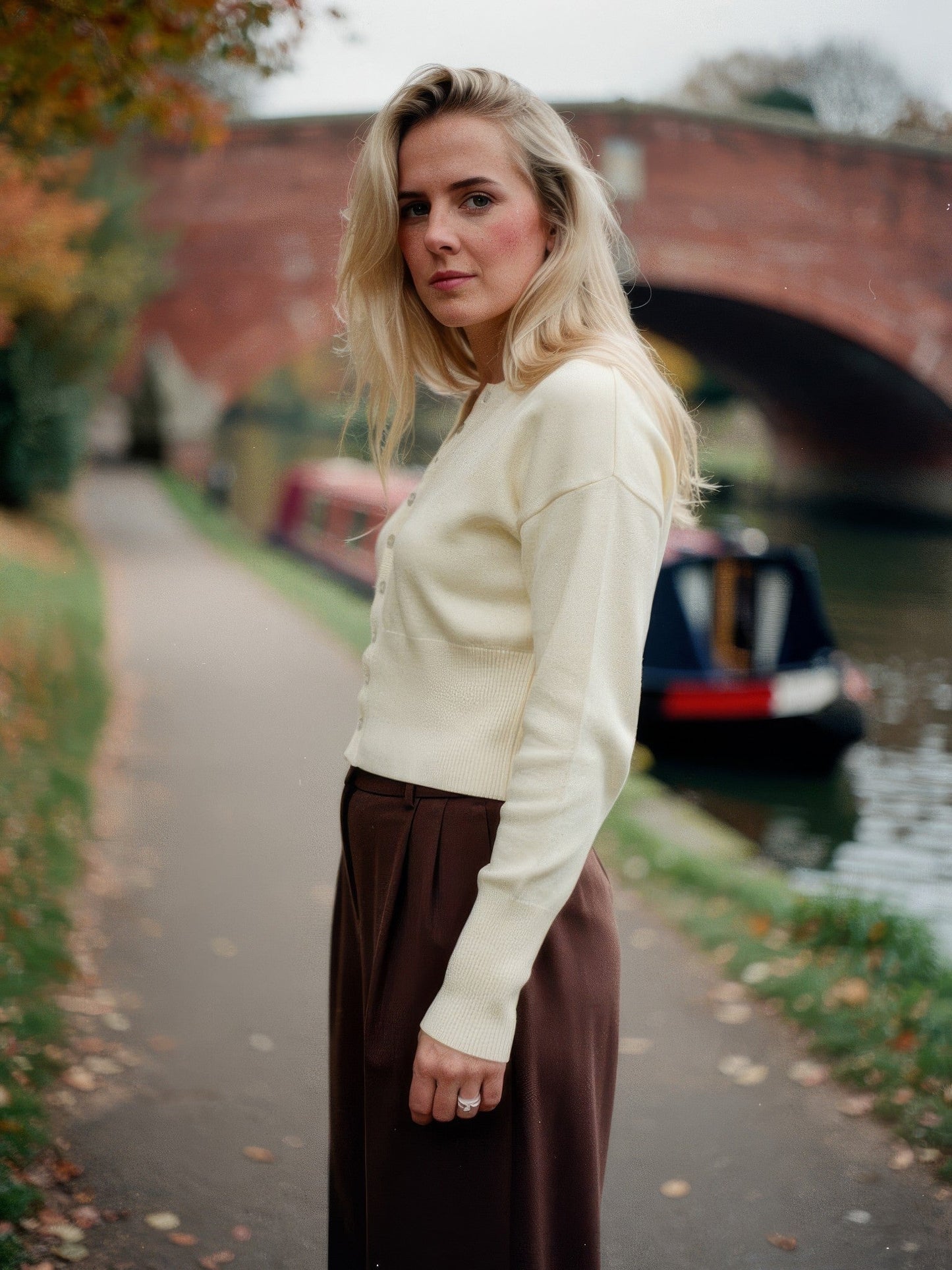 Woman wearing a buttermilk cropped ribbed cardigan on an English canal towpath