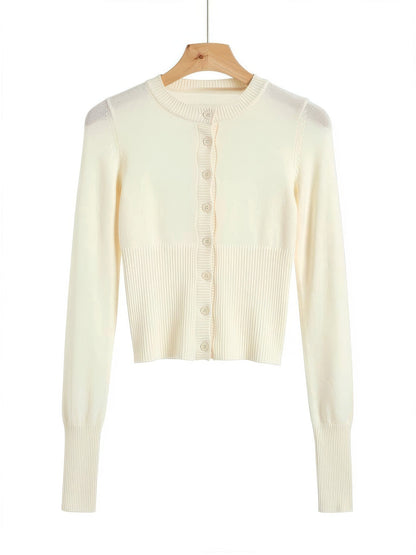 Buttermilk cropped cardigan with a scalloped rib button placket on a wooden hanger