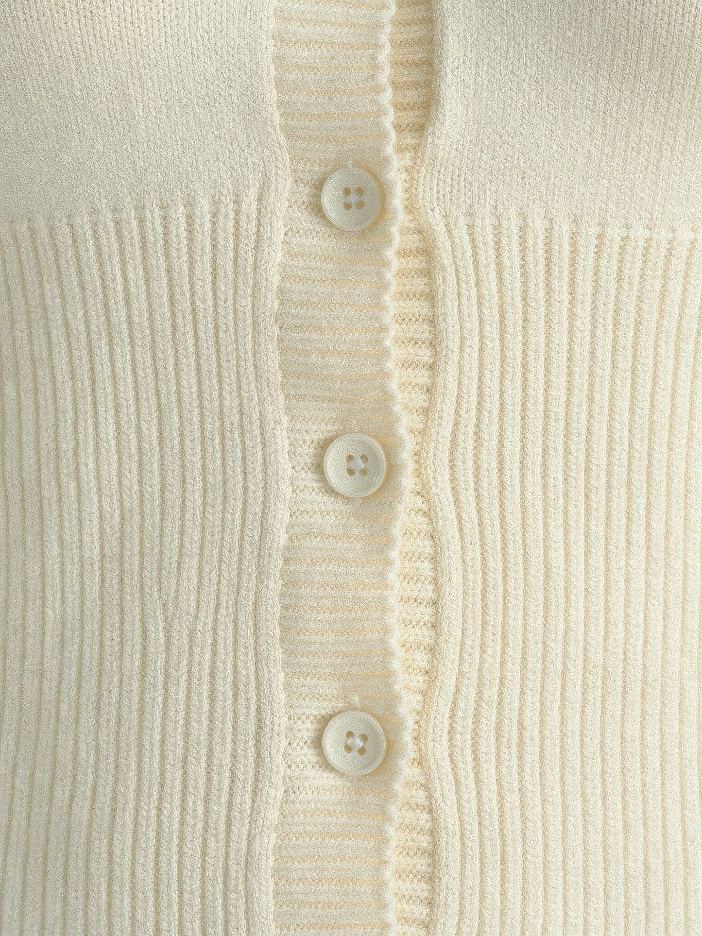 Close-up of the ribbed knit and scalloped button placket of the cropped cardigan