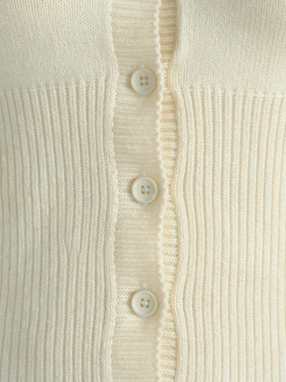Close-up of the ribbed knit and scalloped button placket of the cropped cardigan