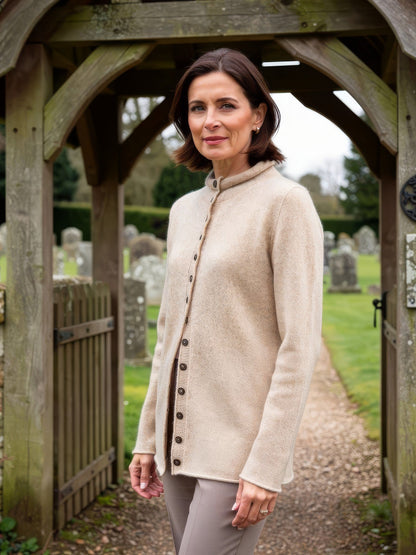 Sand mock-neck wool cardigan worn at a country churchyard gate