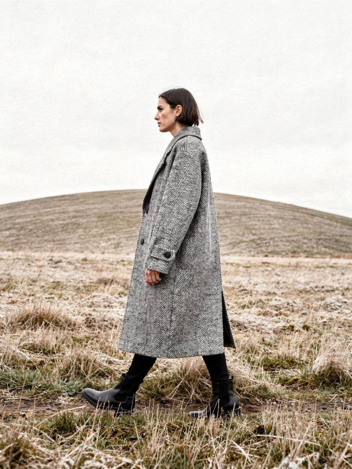 Grey herringbone midi coat worn walking on an English chalk down in winter