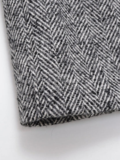 Close up of the woven black and off white herringbone cloth of the midi coat