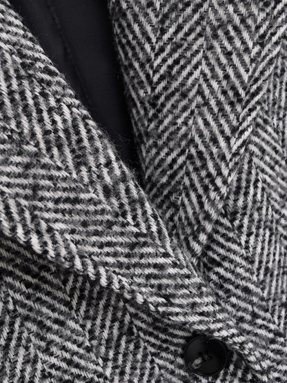 Wide notch lapel and black lining of the grey herringbone midi coat