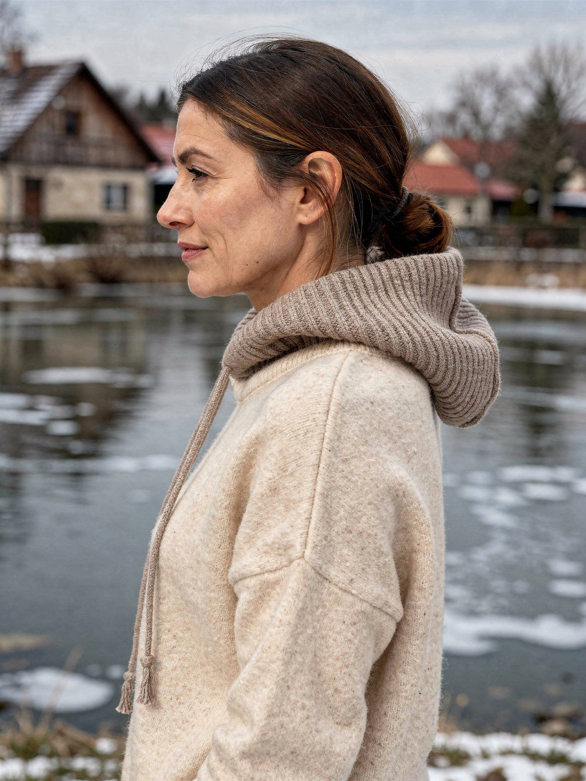 Side profile of the Didbrook knitted hood worn down as a ribbed snood in Silt