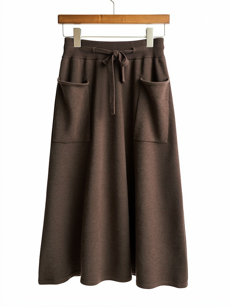 Knitted midi skirt in ganache, a deep chocolate brown, hung flat to show the patch pockets and drawstring waist