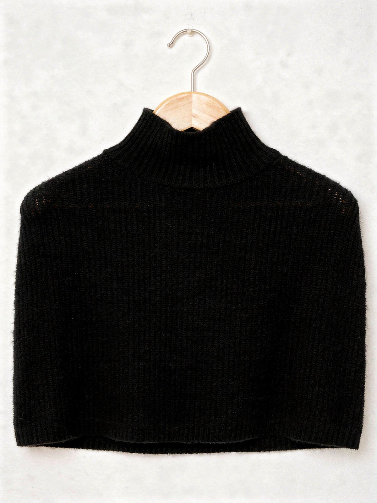 Knitted poncho in Black on a hanger, wide rib funnel neck capelet