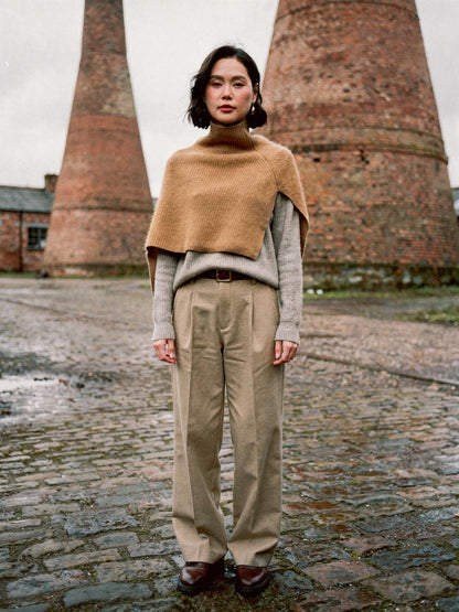 Womens knitted poncho in Bran worn over a jumper, wide rib with a standing funnel neck collar