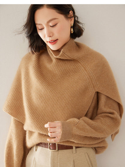 Knitted poncho in Bran with the arms through the side openings, showing how the capelet sits on the shoulders