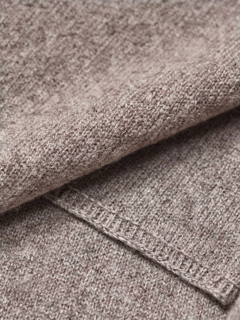 Close up of the fine knitted wool shawl fabric and its narrow linked edge