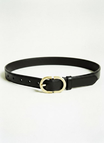 Slim leather belt in black with a brushed gold oval buckle, laid flat