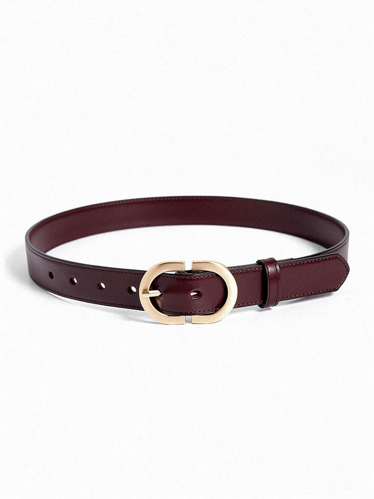 Slim leather belt in mahogany with a brushed gold oval buckle, laid flat