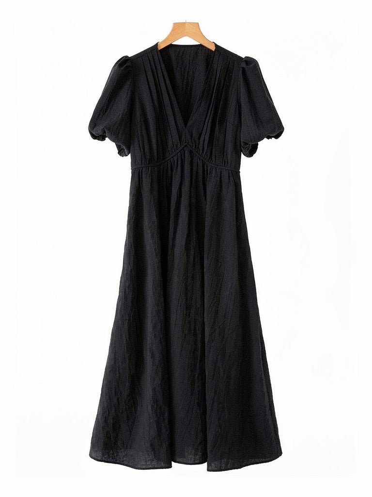 Long black dress on a hanger, showing the deep V neck, short puff sleeves and full gathered skirt