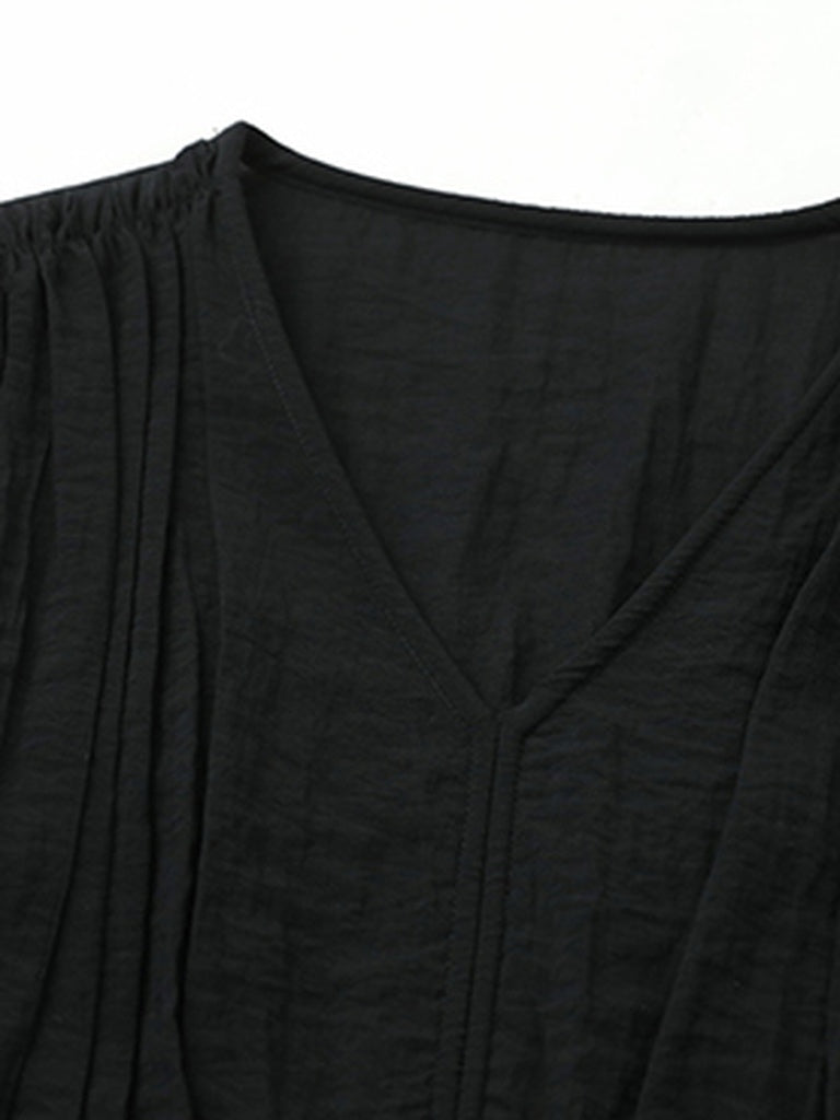 Close-up of the corded V neckline and the fine crinkled weave of the long black dress