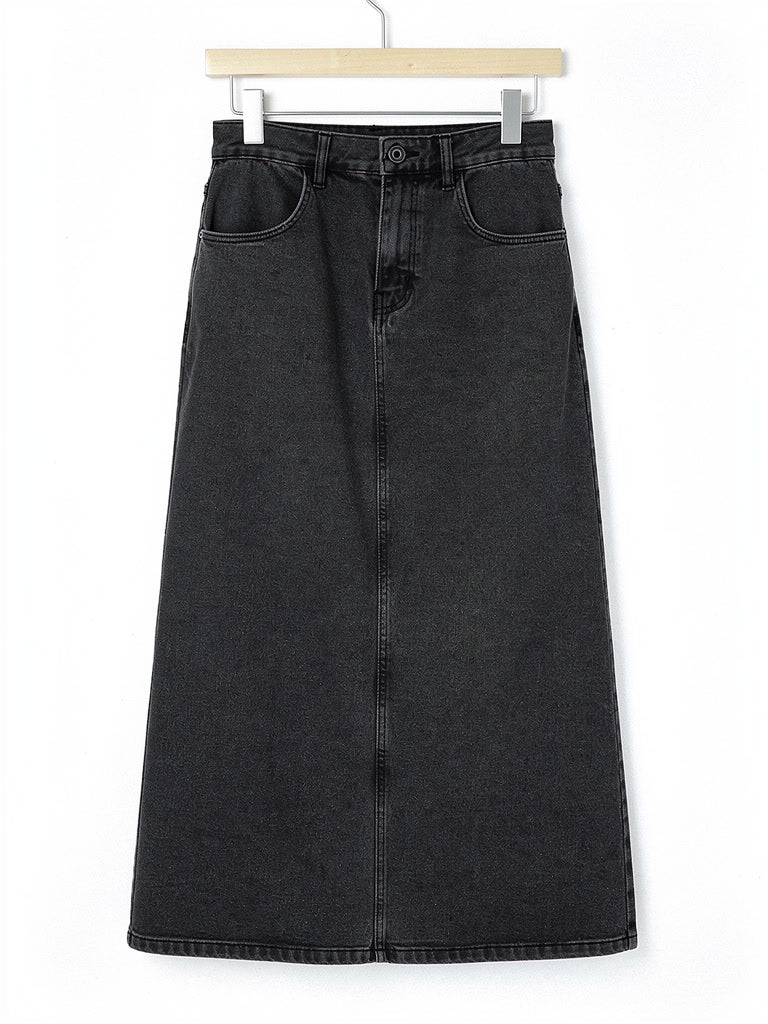 Long jean skirt in gunmetal washed charcoal denim on a plain wooden hanger against white, showing the jean waistband, the tonal topstitching and the long A-line shape
