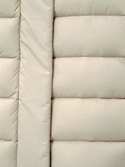 Close up of the wide quilted channels on a long puffer coat in Parchment