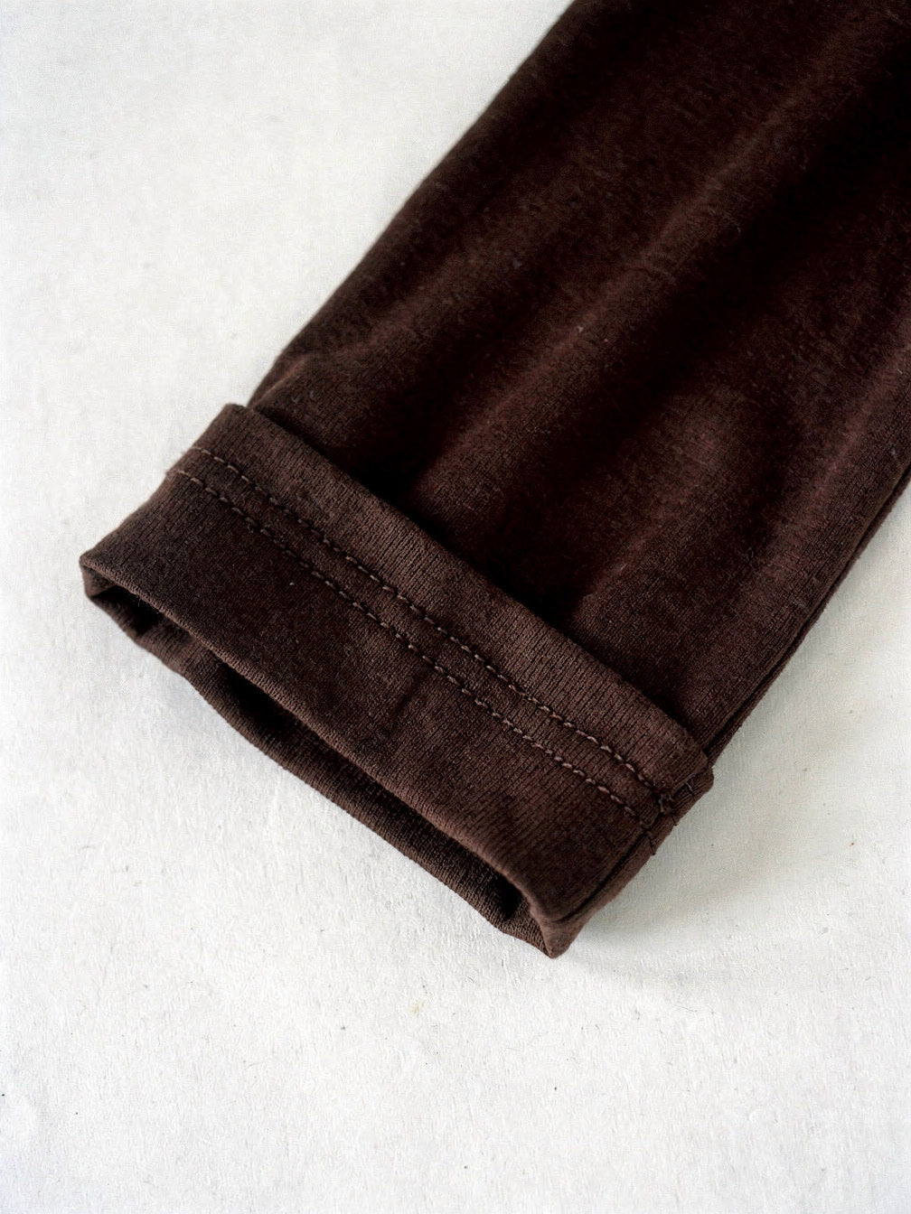 Close detail of the twin needle cuff on the espresso long sleeve top