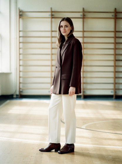 Womens longline blazer in Molasses brown, worn double-breasted with cream trousers