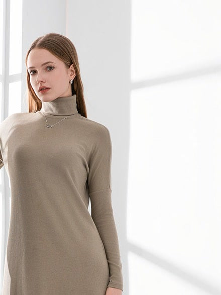 Dropped shoulder and folded roll neck of the Hessian maxi jumper dress, worn
