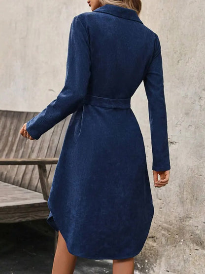 Midnight blue corduroy dress seen from behind, plain back and curved hem