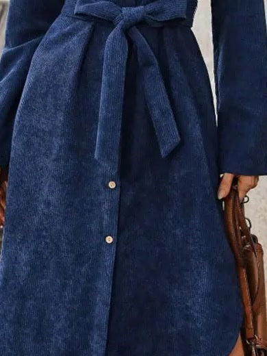 Self fabric corduroy tie belt knotted at the waist of the midnight blue dress