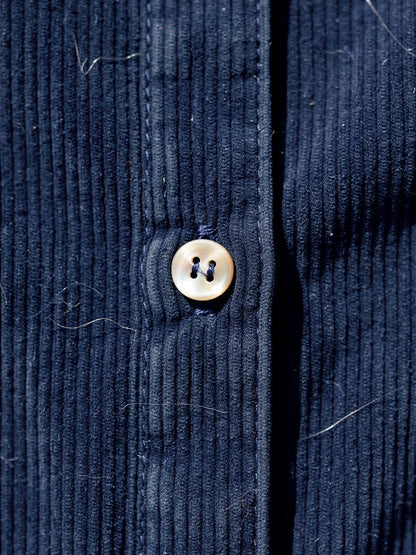 Close up of the fine wale corduroy and ivory tone button on the midnight blue dress