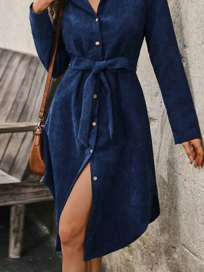 Midnight blue corduroy dress worn open at the hem, midi length