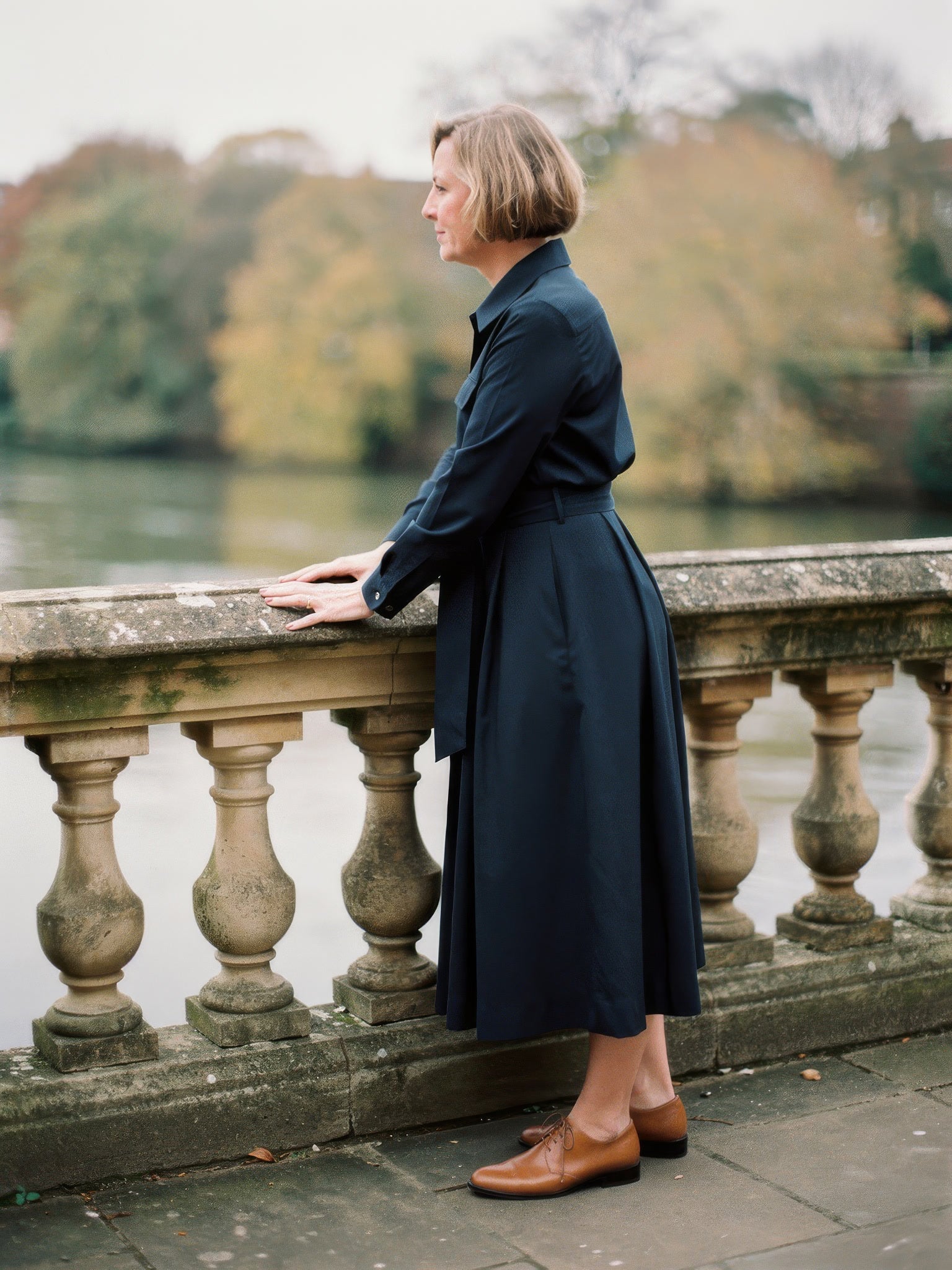 Navy midi shirt dress worn by a stone balustrade
