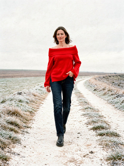 Off the shoulder jumper in Scarlet, worn with jeans on a chalk track