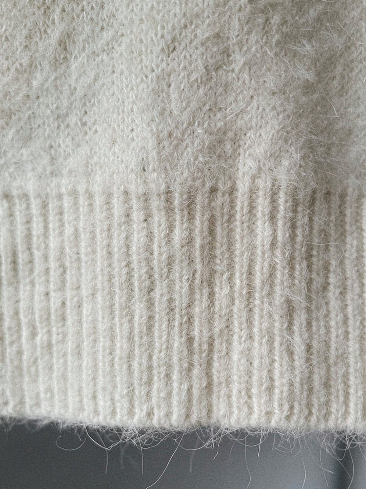 Close-up of the brushed halo knit and deep ribbed hem of the crew neck jumper