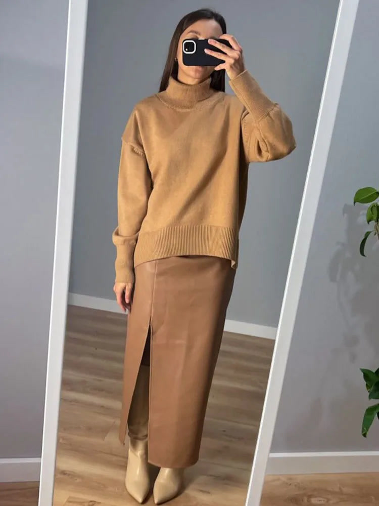 The camel oversized funnel neck jumper worn full length in a mirror photo