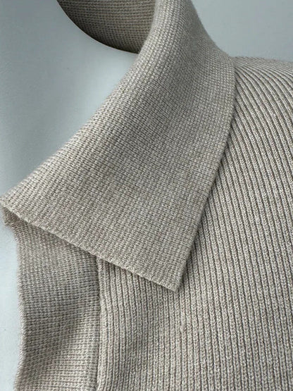 Open shirt collar of the knitted jumper dress in Oat Marl, folded flat over the fine rib
