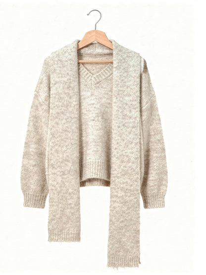 Oversized V neck jumper and matching scarf in Rushlight cream, shown on a wooden hanger